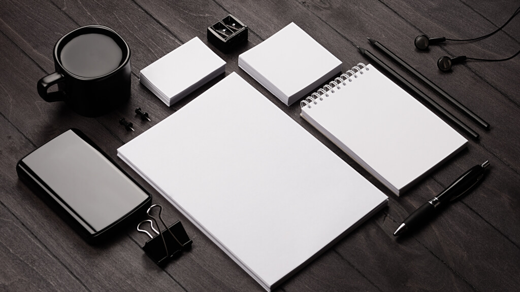Office Depot stämningsbild mörk med vita dokument och kaffekopp påminner om ett ordnat skrivbord